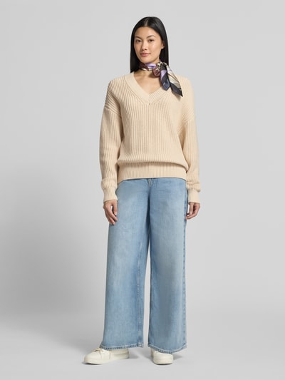 Vrouwenmodel draagt beige regular fit pullover uit katoenmix model 'SELMA' van Selected, Dames pullover, lichte jeans, witte schoenen, volledige vooraanzicht.