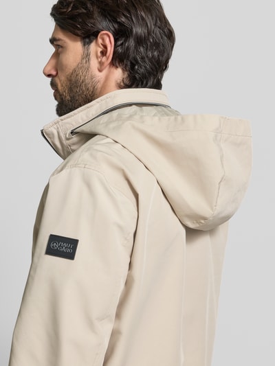 Männermodel trägt Regular Fit Jacke mit Kapuze von NAUTGÅRD in Beige, sichtbare Kapuze und Stehkragen, Nahaufnahme Oberkörper, Rückansicht.