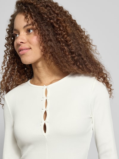 Frauenmodel trägt Slim Fit Langarmshirt aus Baumwoll-Mix Modell 'FEMKE' von Only in Cremeton, Feinripp-Textur, unifarben, Nahaufnahme Oberkörper.