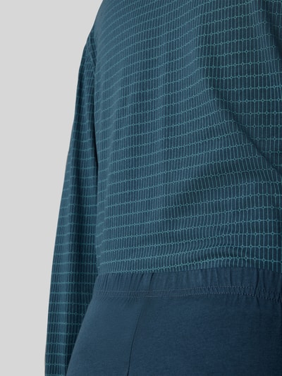Männermodel trägt Regular Fit Pyjama-Set aus reiner Baumwolle von SCHIESSER, dunkelblau mit feinem Gittermuster, Nahaufnahme Oberkörper.