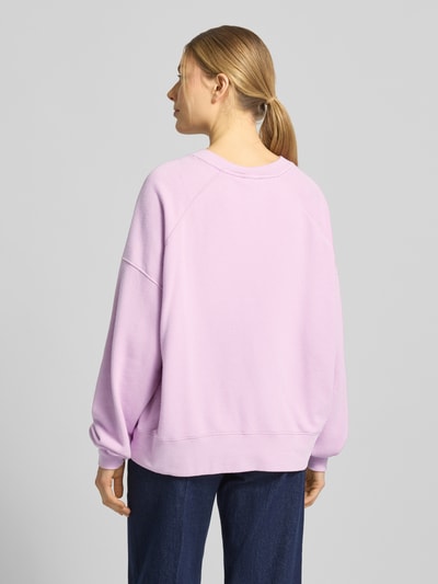 Frauenmodel trägt Sweatshirt mit stark überschnittenen Schultern Modell 'ATUBAY' von American Vintage in Flieder, lockerer Schnitt, Baumwoll-Mix, Ganzkörperansicht Rückansicht.