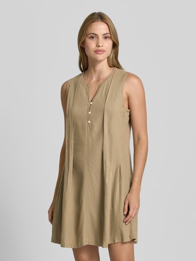 Frauenmodel trägt Minikleid aus Leinen-Viskose-Mix Modell 'LINNO' von ICHI, beige, gerader Schnitt, V-Ausschnitt, Knopfleiste, Ganzkörperansicht von vorne.