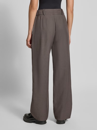 Frauenmodel trägt Weite Hose mit Eingrifftaschen Modell 'LINDA' von ONLY in Braun, lockerer Schnitt, glatte Textur, Ganzkörperansicht Rückansicht. Damen Weite Hose von ONLY.