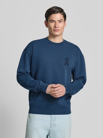 Männermodel trägt Relaxed Fit Sweatshirt aus reiner Bio-Baumwolle Modell 'ICONIC GMT DYE' von Armedangels, Optik: Unifarben, Logo-Stitching, Rundhals, Langarm, Ärmelabschluss und Rumpfabschluss gerippt, Materialverarbeitung: Sweat, Ganzkörperansicht von vorne.