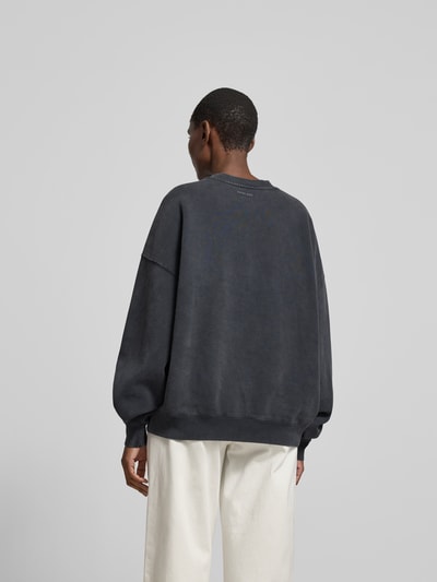 Frauenmodel trägt Oversized Sweatshirt aus Baumwolle von Anine Bing in Dunkelgrau mit Elastische Abschlüsse, Überschnittene Schultern, Rückenlänge bei Größe S 63 cm, Ganzkörperansicht Rückansicht.