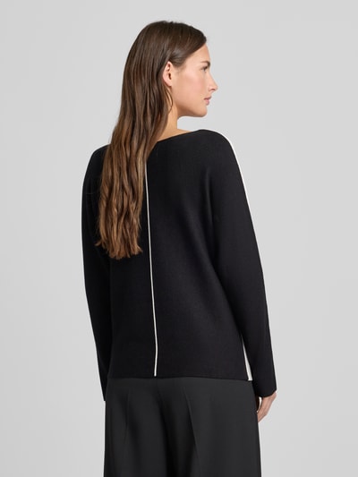 Frauenmodel trägt Regular Fit Pullover aus Viskose-Mix Modell 'Dezember' von More & More in Schwarz mit weißer Ziernaht, Strick-Optik, Rückenansicht.