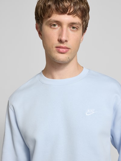 Männermodel trägt Sweatshirt mit Label-Stitching und Rundhalsausschnitt von Nike in Hellblau, Baumwoll-Mix, Nahaufnahme Oberkörper.