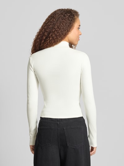 Frauenmodel trägt Slim Fit Jacke mit Stehkragen von Gina Tricot aus elastischem Baumwoll-Mix in Weiß, Rückenlänge 50 cm, Ganzkörperansicht Rückansicht.