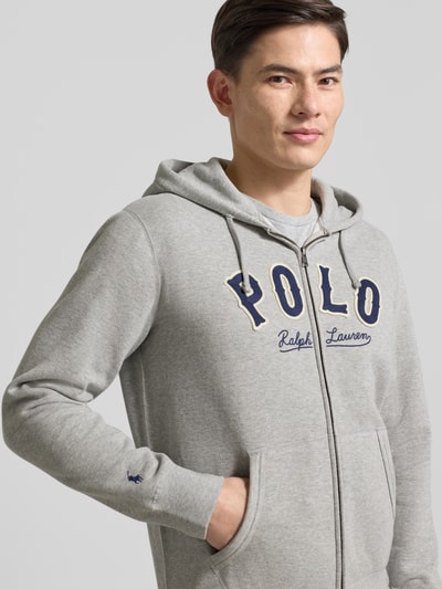 Männermodel trägt Sweatjacke mit Label-Stitching und Känguru-Tasche von Polo Ralph Lauren aus grauem Baumwoll-Mix, Regular-Fit, Nahaufnahme Oberkörper.