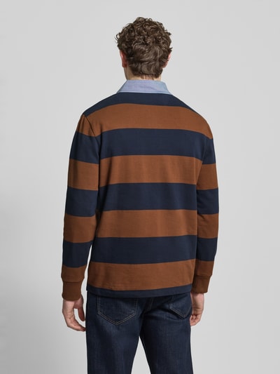 Męskimodel nosi bluza z wyhaftowanym logo Sweatshirt mit Label-Stitching od Gant, bawełna, krój regular fit, kołnierzyk polo, długość tyłu 72 cm, prążkowane zakończenia rękawów, widok całej sylwetki od tyłu.