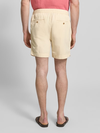 Männermodel trägt Regular Fit Shorts mit elastischem Bund Modell 'SUNFADED' von Gant in Beige aus Reine Baumwolle, Ganzkörperansicht Rückansicht. Herren Shorts mit Tunnelzug, Bundweite bei Größe M: 43 cm, Innenbeinlänge bei Größe M: 15 cm.