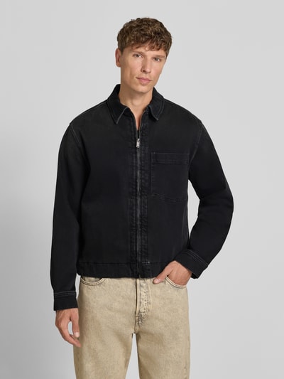 Mężczyznamodel nosi czarną kurtkę jeansową Regular Fit Jeansjacke aus Baumwoll-Mix Modell 'LUNEY BO REF' von BOSS Orange, Ganzkörperansicht von vorne.