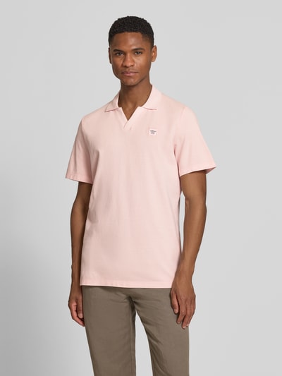Męski model nosi Regular Fit Poloshirt aus reiner Baumwolle od s.Oliver RED LABEL w jednolitym różowym kolorze, piqué, całkowity widok z przodu.