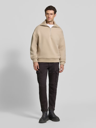 Männermodel trägt Cargohose mit Pattentaschen Modell 'EXPEDIZOR' von PME Legend in Dunkelbraun, Skinny Fit, Ganzkörperansicht von vorne.