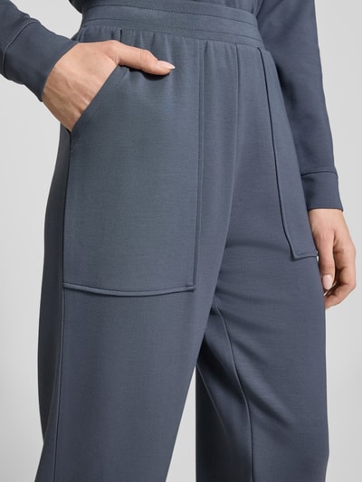 Frauenmodel trägt Sweatpants mit Eingrifftaschen und Aufschlag von Christian Berg Woman, Modal-Mix, Relaxed-Fit, Nahaufnahme Oberkörper.
