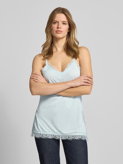 Vrouwenmodel draagt Regular Fit Top mit Spitzenbesatz van Gina Tricot in lichtblauw met V-hals, verstelbare spaghetti-bandjes, kanten details; zichtbare lengte rug bij maat S 47 cm, voorkant bovenlichaam close-up