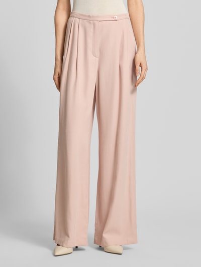 Frauenmodel trägt Bundfaltenhose aus Viskose-Mix mit Knopfverschluss von Jake*s Collection, Wide Leg, zart rosa, fließende Textur, Nahaufnahme Oberkörper.