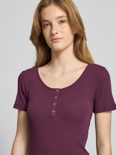 Frauenmodel trägt Slim Fit T-Shirt aus Baumwoll-Mix Modell 'KITTE' von Pieces in Dunkellila, gerippte Textur, Damen T-Shirt, Nahaufnahme Oberkörper.