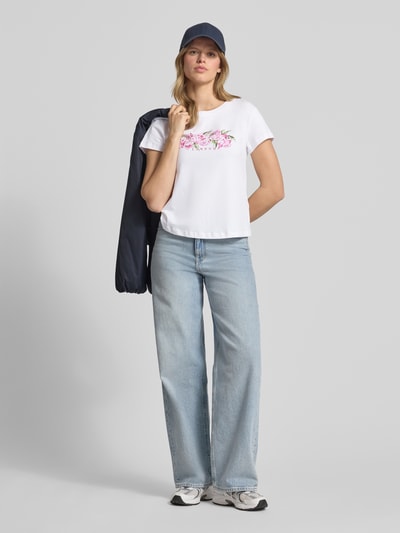 Frauenmodel trägt Damen T-Shirt von Pepe Jeans, Modell 'MAHINA', Optik: Unifarben, Passform: Regular-Fit, Label-Schriftzug, Motiv-Print, Rundhals, Ärmelform: Kurzarm, Material: Reine Baumwolle, Ganzkörperansicht von vorne.