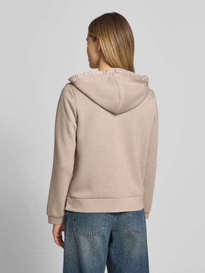 Modelka nosi Regular Fit Sweatjacke mit Viskose-Anteil von Tom Tailor, beżowa, gładka dzianina, kaptur, dżinsy, widok całej sylwetki z tyłu.