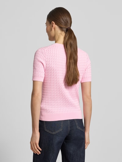 Frauenmodel trägt Slim Fit T-Shirt aus reiner Baumwolle von Tommy Hilfiger, Optik: Unifarben, Zopfmuster, Strick, Kurzarm, Rundhals, Logo-Detail, rosa, Ganzkörperansicht Rückansicht.