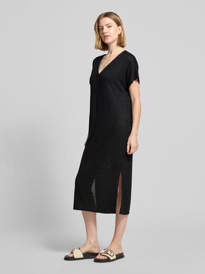 Frauenmodel trägt Strickkleid mit V-Ausschnitt Modell 'Delia' von Soyaconcept, schwarzer Viskose-Mix mit Stretch-Anteil, Gerader-Schnitt, Midikleid, Ganzkörperansicht von vorne. Rückenlänge 112 cm, Brustweite 54 cm, Ärmellänge 24 cm.