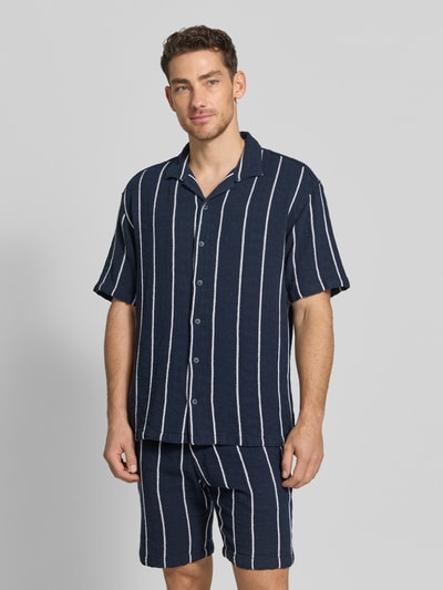 Männermodel trägt Regular Fit Freizeithemd mit Streifenmuster von MCNEAL aus reiner Bio-Baumwolle, dunkel mit weißen Streifen, Reverskragen, Knopfleiste, Ganzkörperansicht von vorne.