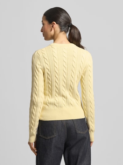 Vrouwenmodel draagt 'Strickjacke mit Zopfmuster und Rundhalsausschnitt' van JAKE*S STUDIO WOMAN, puur katoen, slim fit, kabelpatroon, ronde hals, knoopsluiting, ruglengte maat S 52 cm, mouwlengte 67 cm, zacht geel, rechte vormen, gebreide textuur. Ganzkörperaanzicht achteraan.