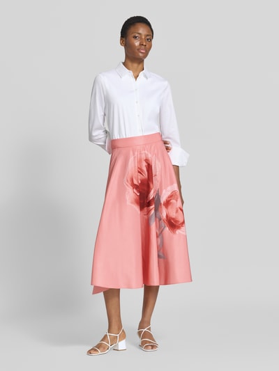 Kobiece model prezentuje spódnica midi z kwiatowym nadrukiem Model 'Darra' od Ted Baker, w odcieniach różu, Linia a, zamek błyskawiczny, Szerokość w rozmiarze 36: 37 cm, całkowita długość w rozmiarze 36: 76 cm, widok całej sylwetki z przodu
