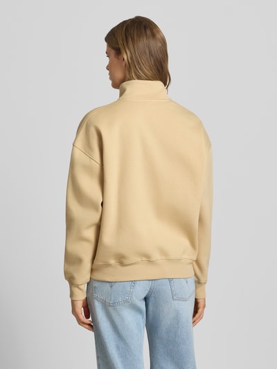 Männermodel trägt beżową Sweatjacke mit Stehkragen Modell 'Tanisha' von LeGer by Lena Gercke, bawełniany mix, oversized, Ganzkörperansicht Rückansicht.