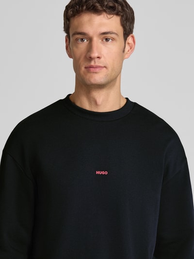 Männermodel trägt Regular Fit Sweatshirt aus reiner Baumwolle Modell 'DUBRAXO' von HUGO, Optik: Unifarben, Nahaufnahme Oberkörper.