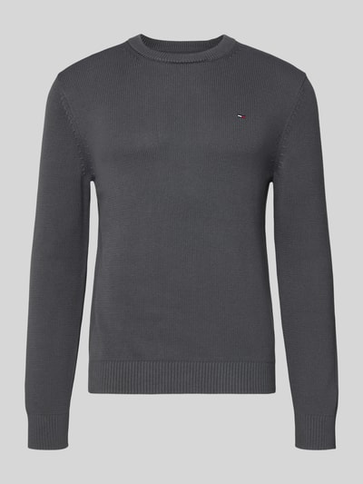 Produktfoto, Regular Fit Strickpullover aus reiner Baumwolle von Tommy Jeans, jednolity, krój regular fit, detal z logo, okrągły dekolt, długie rękawy, ściągacze, kolor ciemnoszary, faktura dzianiny
