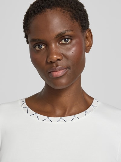 Frauenmodel trägt T-Shirt in Ripp-Optik mit Rundhalsausschnitt von Marc Cain, Baumwoll-Elasthan-Mix, Slim Fit, Nahaufnahme Oberkörper.