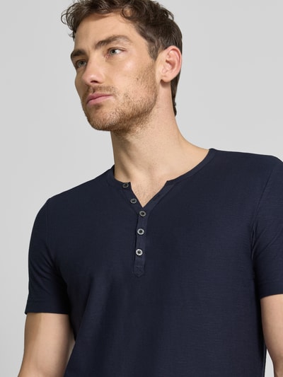 Männermodel trägt T-Shirt mit V-Ausschnitt und Knopfleiste von MCNEAL, Herren T-Shirt aus Reine Baumwolle, Regular-Fit, Nahaufnahme Oberkörper.