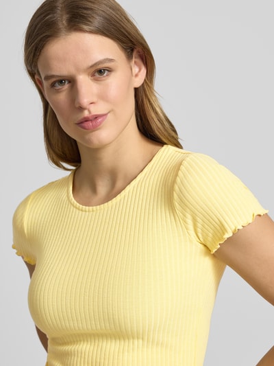 Modelka kobieca nosi damski t-shirt Slim Fit T-Shirt mit Viskose-Anteil Modell 'EMMA' od Only, jednokolorowy, faktura w paski, okrągły dekolt, krótki rękaw z falowanym zakończeniem, żakard, mieszanka materiałów z dodatkiem wiskozy, widok z przodu, zbliżenie na górę ciała.