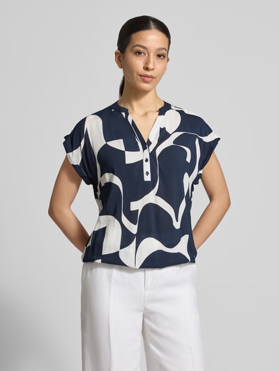 Frauenmodel trägt Regular Fit Bluse aus reiner Viskose Modell 'Miriama' von ZABAIONE, Tunika-Ausschnitt, Kurzärmelig, elastischer Bund, Rückenlänge bei Größe S: 62 cm, Dunkelblau mit weißen abstrakten Formen, glatte Textur, Ganzkörperansicht von vorne.