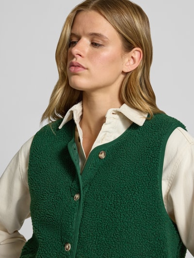 Kobiece model prezentuje Regular Fit kamizelkę w imitacji futerka model 'BABY' od ONLY, zieleń, kremowa koszula, zbliżenie górnej części, kamizelka damska