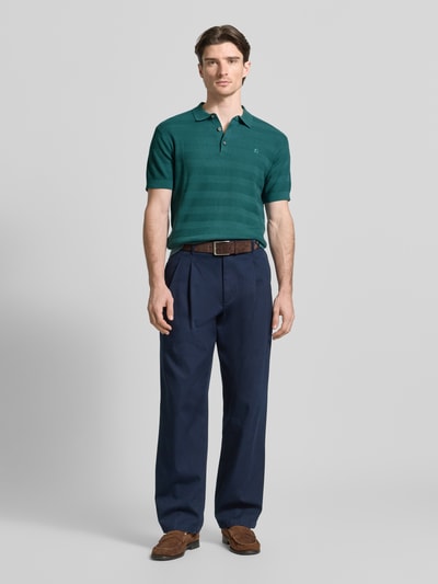 Männermodel trägt Slim Fit Poloshirt mit Logo-Stitching von Lerros aus Reine Baumwolle in Grün, Polokragen, kurze Knopfleiste, Label-Patch, Rückenlänge bei Größe M 68 cm, Ganzkörperansicht von vorne.