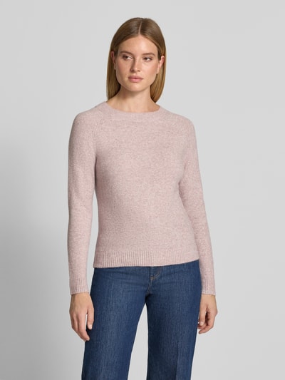 Frauenmodel trägt Regular Fit Pullover mit Rundhalsausschnitt Modell 'DOFFY' von VERO MODA in zartrosa, feine Strickstruktur, Ganzkörperansicht von vorne.
