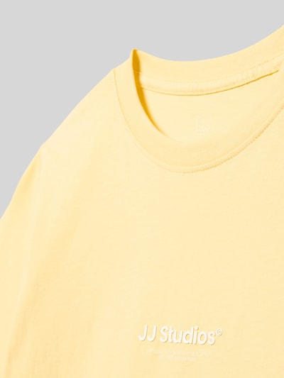 Produktfoto, Kinder T-Shirt aus reiner Baumwolle Modell 'SOHO' von JACK & JONES in Gelb mit Statement-Print und Rundhalsausschnitt, glatte Textur.