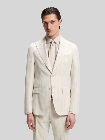 Männermodel trägt Slim Fit Anzug aus Baumwoll-Woll-Mix Modell 'H-HUGE-2PCS-261' von BOSS in Beige mit gestreiftem Allover-Muster, Ganzkörperansicht von vorne.