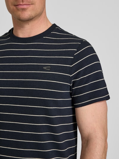 Männermodel trägt T-Shirt mit Streifenmuster und Logo van camel active, katoen, regular fit, donkerblauw met lichtstrepen, logo op borst, ronde hals, Nahaufnahme Oberkörper
