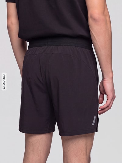 Mannelijk model draagt zwarte Regular Fit Sportshorts met logoprint model 'M PWRMODE 5' van PUMA, Heren Sportshorts, volledige achteraanzicht, KI-modifiziertes Bild.