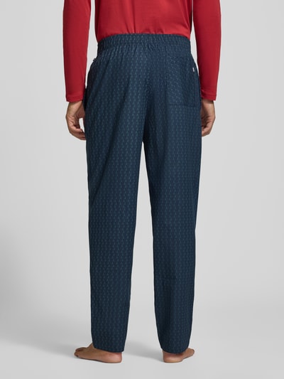 Männermodel trägt Sweathose Modell 'Chris Pants' von BOSS in Dunkelblau mit elastischem Bund, Baumwollmix, Ganzkörperansicht Rückansicht.