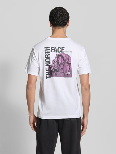 Männermodel trägt T-Shirt mit Logo und Rundhalsausschnitt von The North Face, weiß, Baumwoll-Mix, Regular Fit, Rückenlänge 71 cm, Ganzkörperansicht Rückansicht.