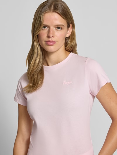 Vrouwenmodel draagt lichtroze Regular Fit T-Shirt uit zuivere katoen model 'Damatee_B' van HUGO, Dames t-shirt van HUGO Blue, close-up bovenlichaam.