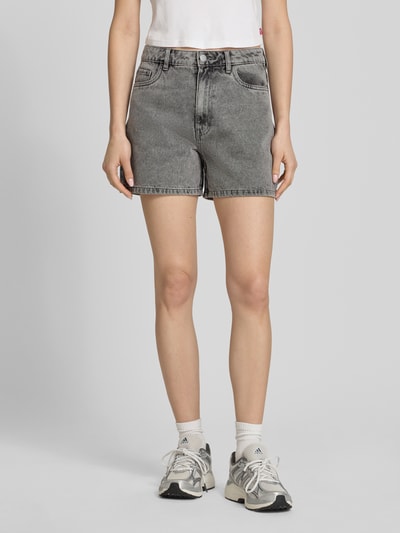 Frauenmodel trägt Regular Fit Jeansshorts aus Baumwoll-Mix Modell 'ABBI' von Pieces, graue Denim-Optik, 5-Pocket-Design, Ganzkörperansicht von vorne.