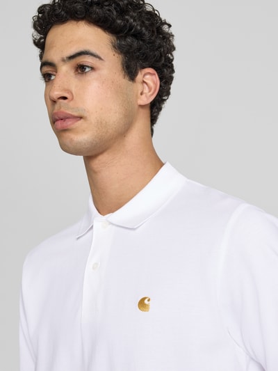 Männermodel trägt Regular Fit Poloshirt mit Label-Stitching von Carhartt Work In Progress aus Reine Baumwolle, Nahaufnahme Oberkörper.