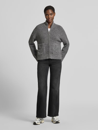 Frauenmodel trägt Bootcut Jeans aus Baumwoll-Mix Modell 'ASTA' von Vero Moda in dunkler Denim-Optik, 5-Pocket-Design, Ganzkörperansicht von vorne.