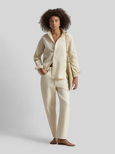 Frauenmodel trägt Hemdbluse mit Knopfleiste von Polo Ralph Lauren aus reiner Baumwolle in Creme, lockerer Schnitt, Label-Stitching, Ganzkörperansicht von vorne.